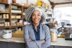 older woman smiling and standing in a store 