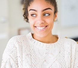 a woman smiling after paying the cost of cosmetic dentistry