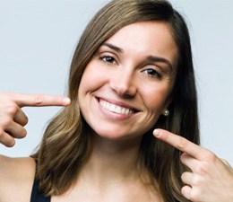 Woman pointing to her smile