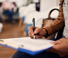 Patient filling out dental insurance form in lobby