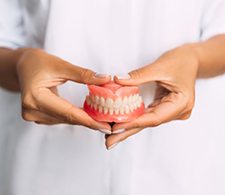 Lady presents viewer with dentures