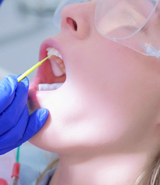 Child receiving fluoride during checkup 