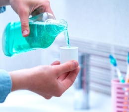 Man pouring mouthwash into the cap