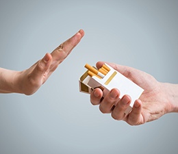 One hand turning down offer of cigarettes from another