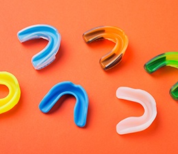 Several colorful mouthguards on an orange background
