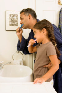 father and daughter brushing teeth thanks to tips from the family dentist waterbury trusts