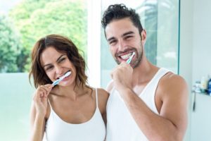 man and woman brushing teeth