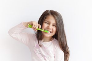 young girl brushing her teeth