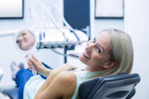 Woman sitting in dental chair at dentist in Waterbury.