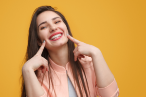 Woman pointing to mouth after root canal therapy