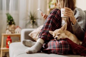 woman relaxing with dog during christmas