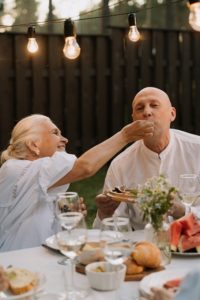 Older woman feeding man food