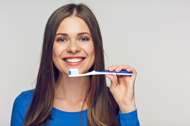 woman brushing with toothpaste for veneers in Waterbury
