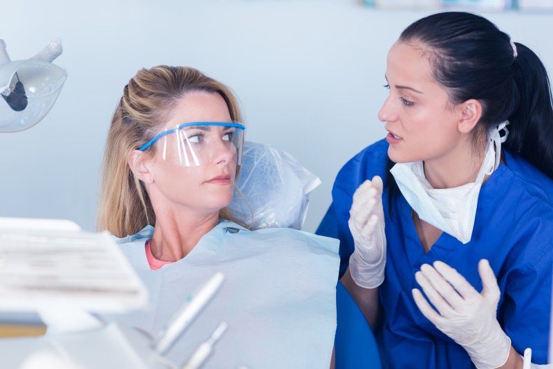 dentist talking to patient about oral bacteria