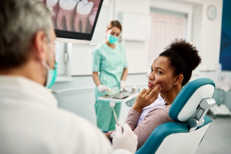 Woman talking to her dentist about tooth pain