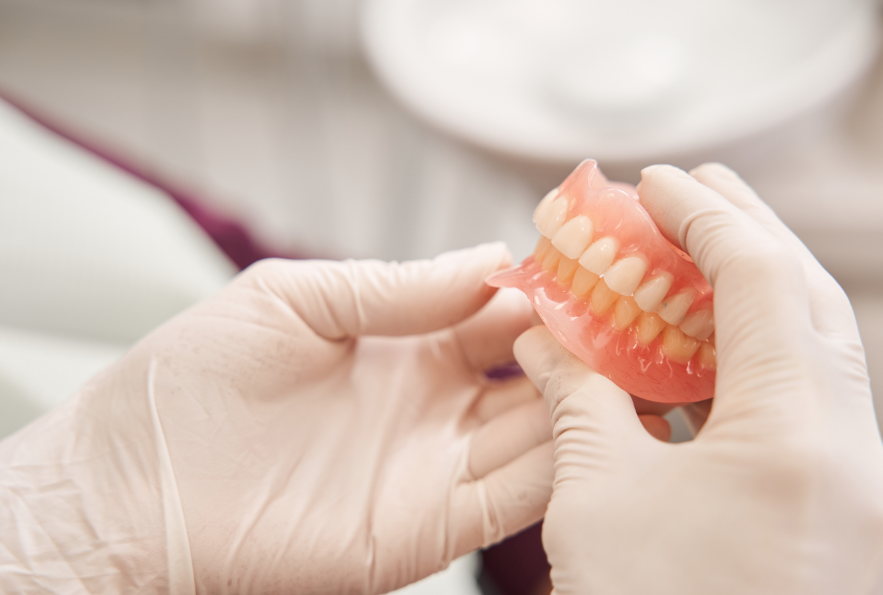 Dentist holding dentures