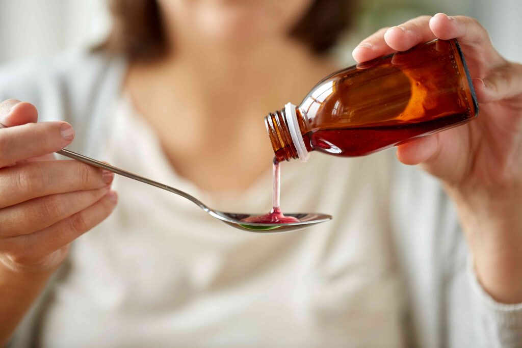 Woman pouring cough syrup